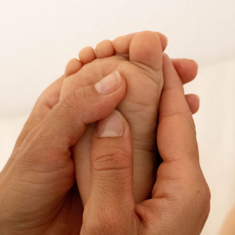 Babymassage am Fuß eines Babys
